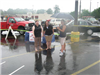 Group of Volunteers Standing in Rain with Umbrellas