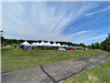 A landscape picture showing multiple tents with a blue sky 