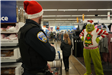 2 People stand in a store aisle while the green grinch watches them shop