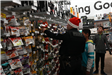 3 People Stand shopping in an aisle with fishing lures and fishing rods