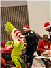 An officer grabs the grinch as he is running away