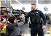 An officer and a child are sharing a hand shake