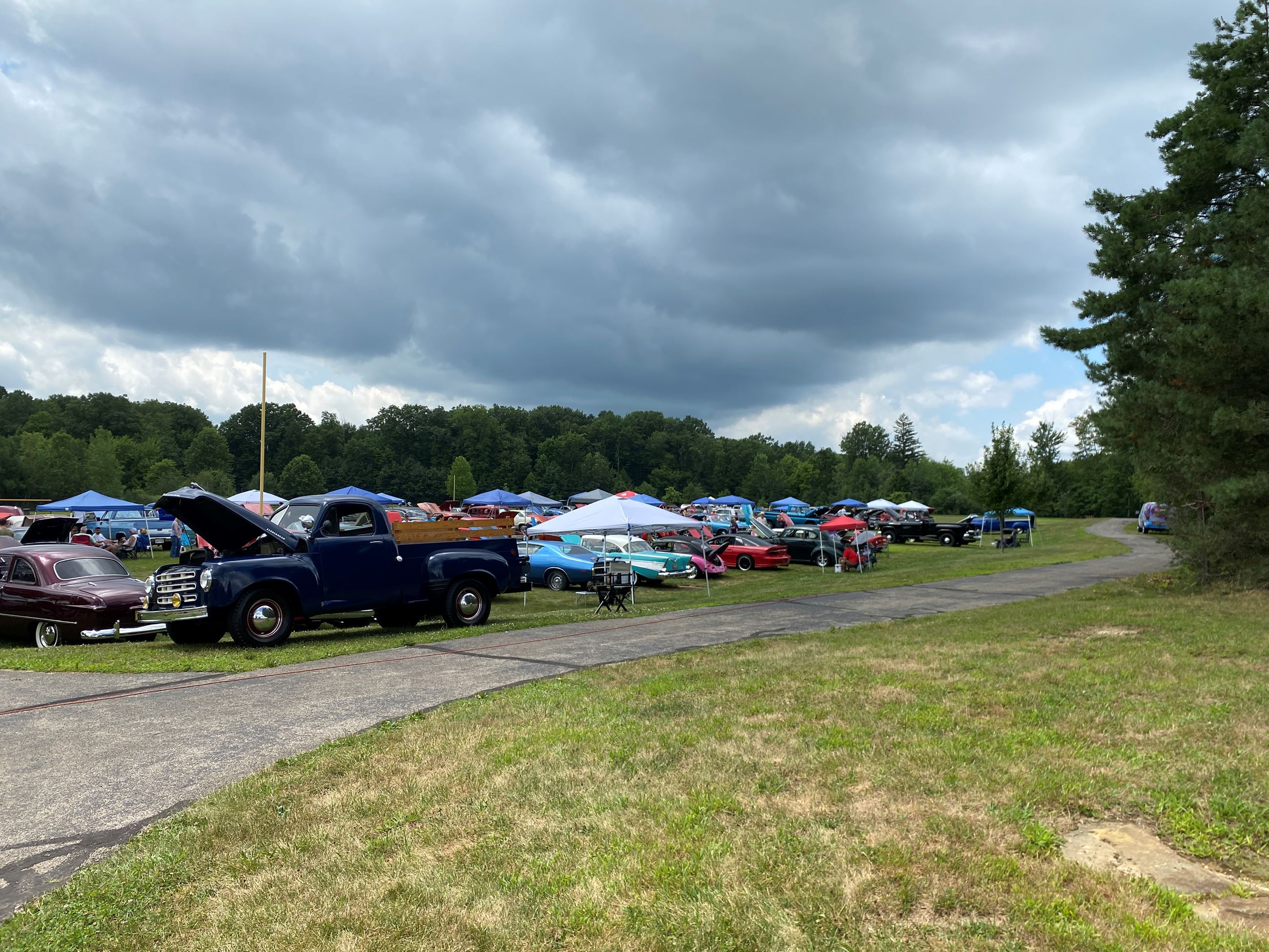 A landscape picture of all the cars participating in the Car Show, cars are in the distance 