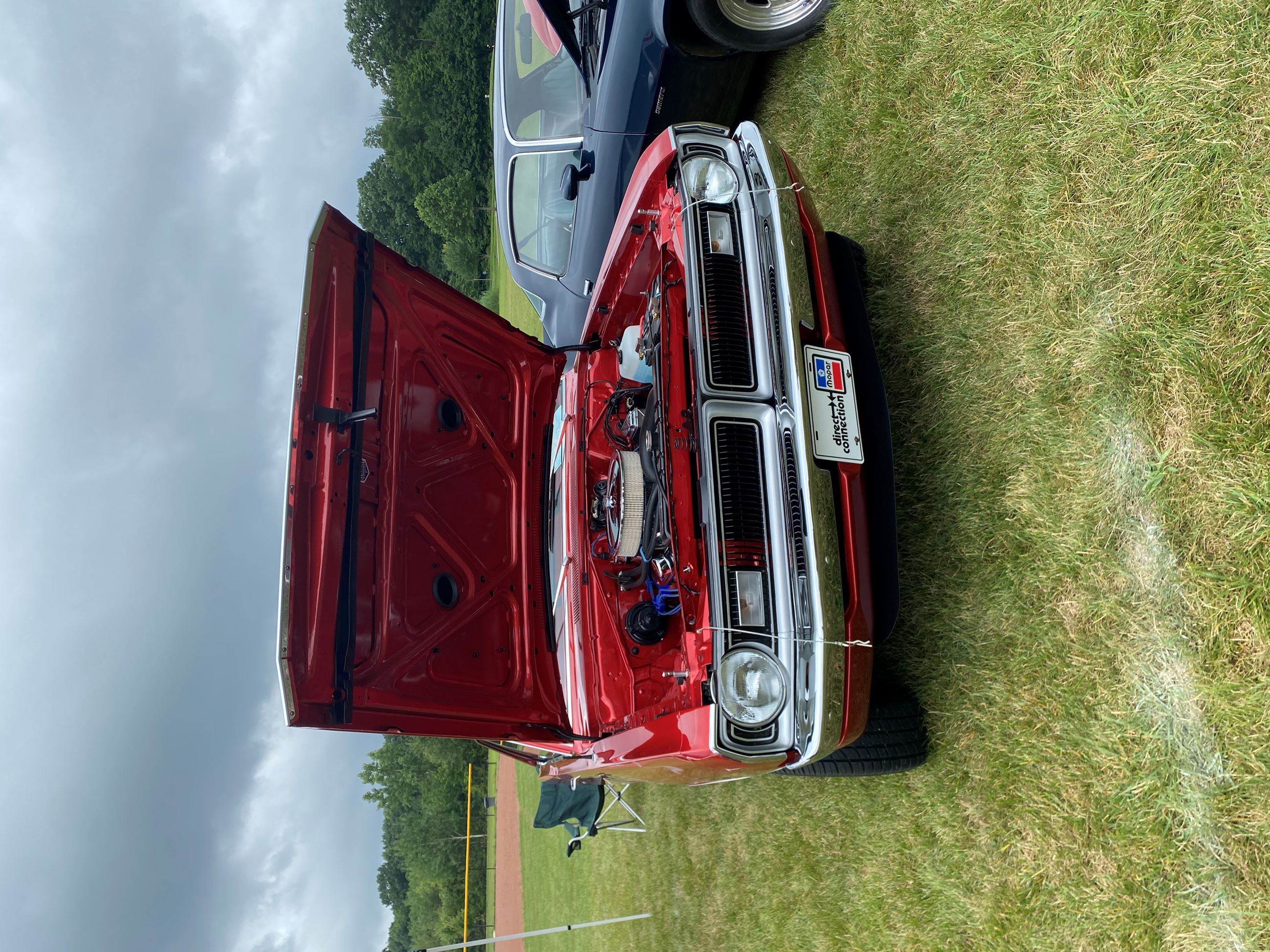 A Red Muscle Car Has It's Hood Open at Copley Car Show 2025