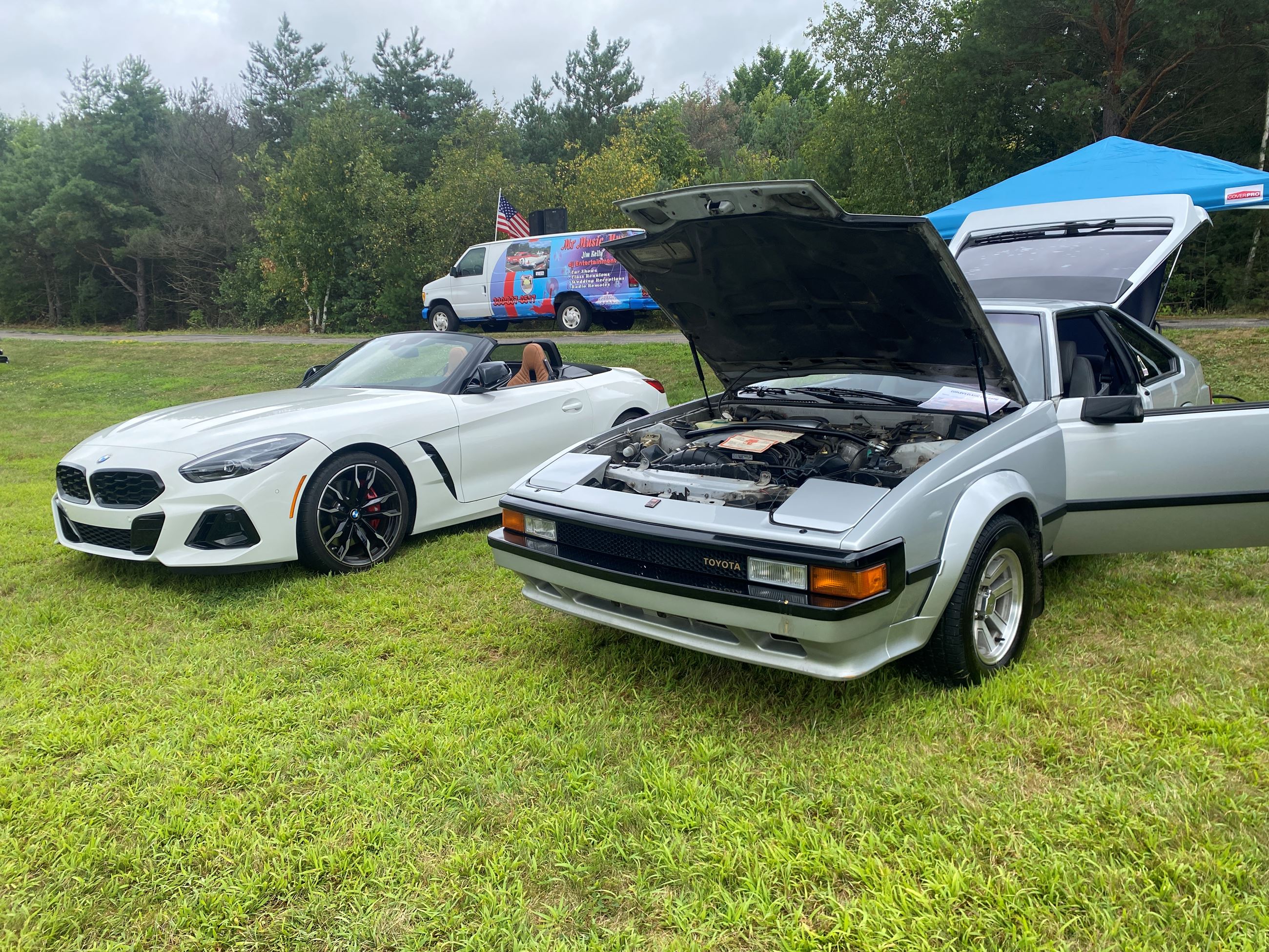 Two Cars, one on the left is a White BMW and the Right Is a Silver Sedan On Display at Car Show 2025