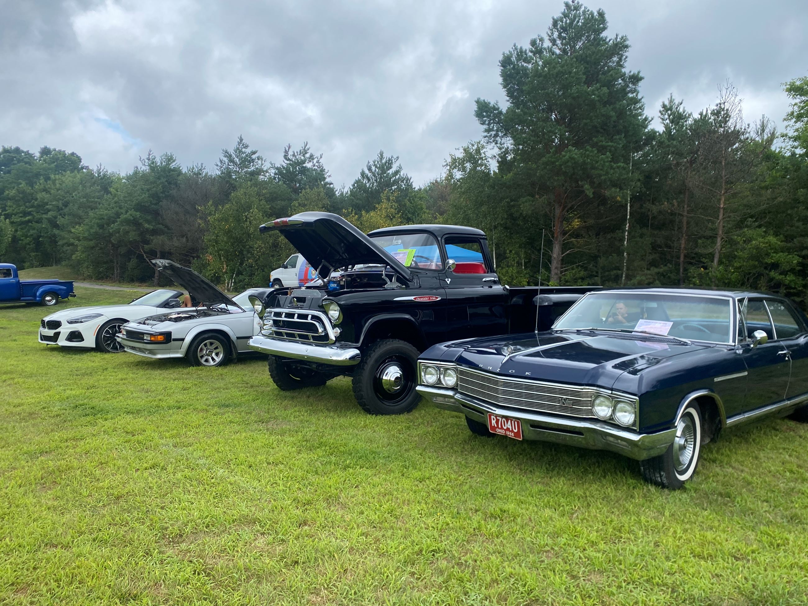 A Row of Cars and 1 Vintage Lifted Truck On Display at Car Show 2025