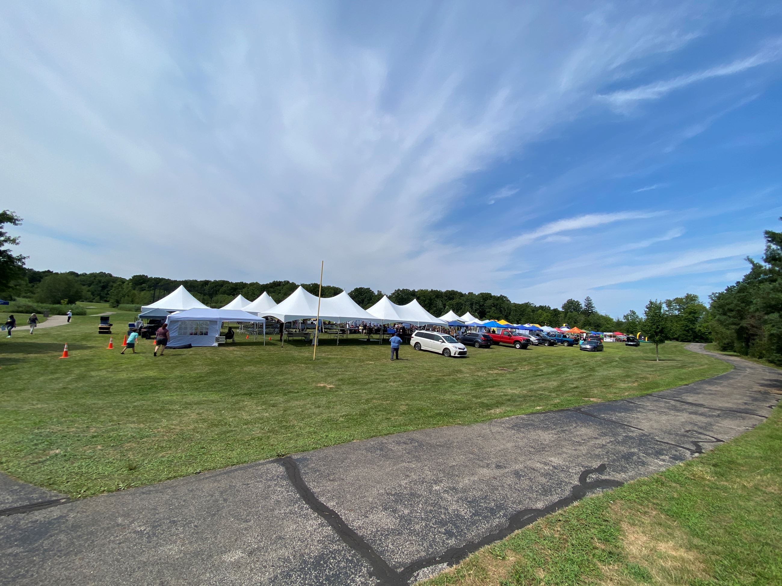 A landscape picture showing multiple tents with a blue sky 